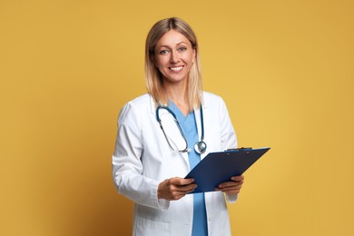 Portrait of doctor in medical uniform with stethoscope and clipboard on yellow background