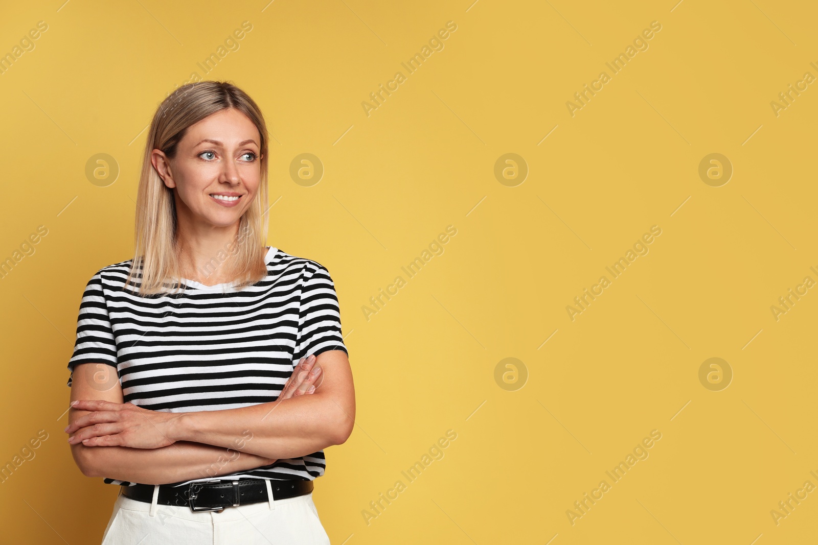 Photo of Portrait of beautiful smiling woman on yellow background, space for text