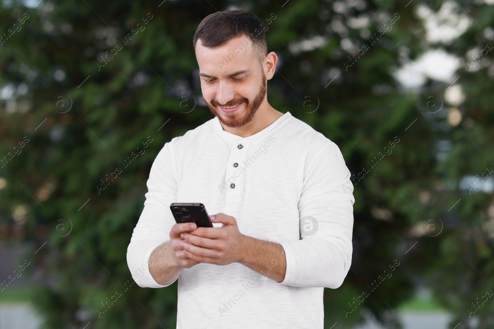 Photo of Happy man using smartphone on blurred background