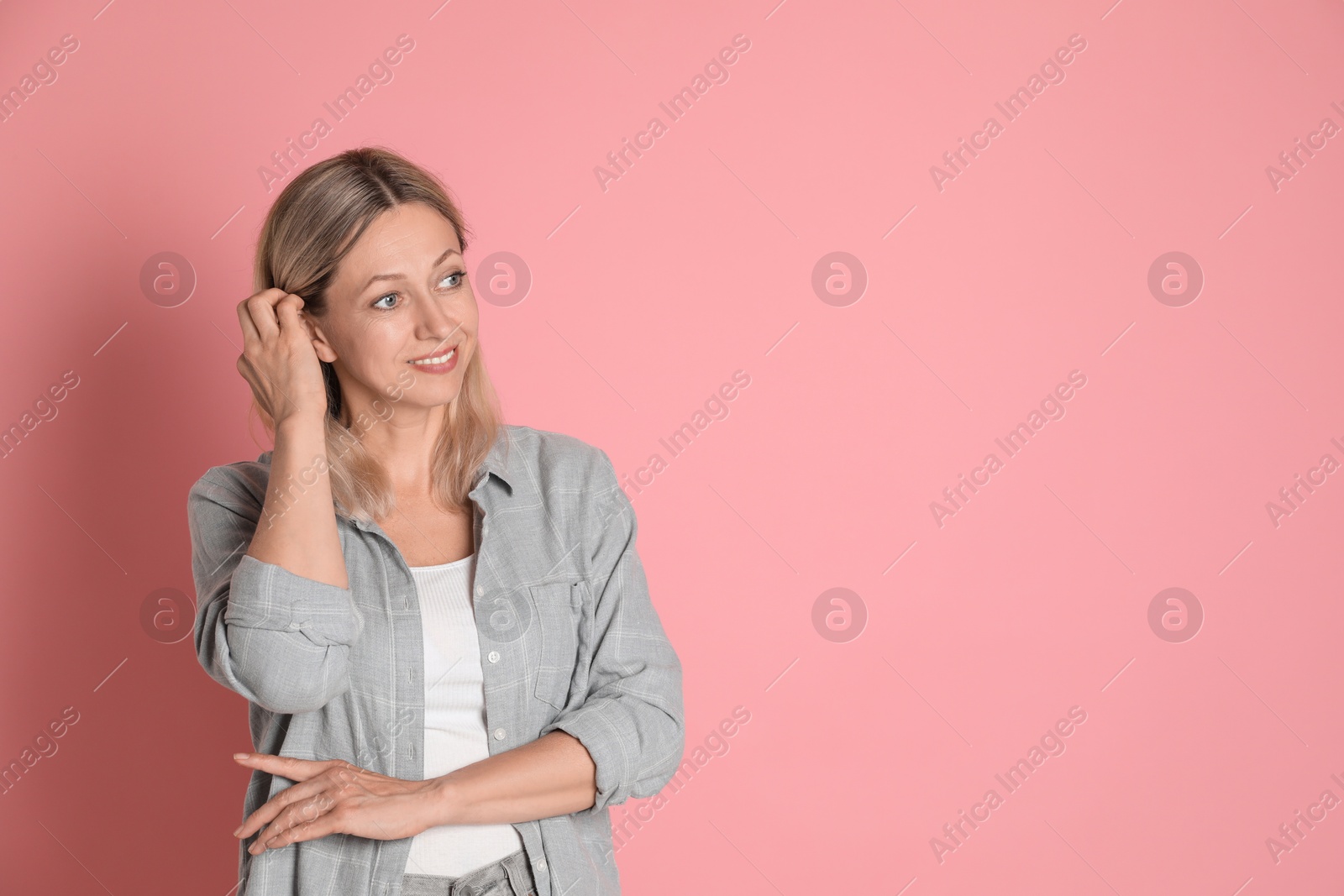 Photo of Beautiful smiling woman on pink background, space for text