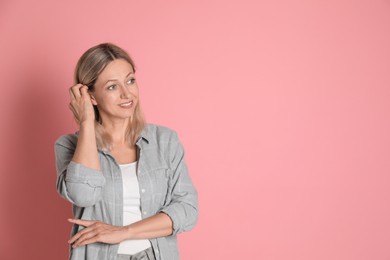 Beautiful smiling woman on pink background, space for text