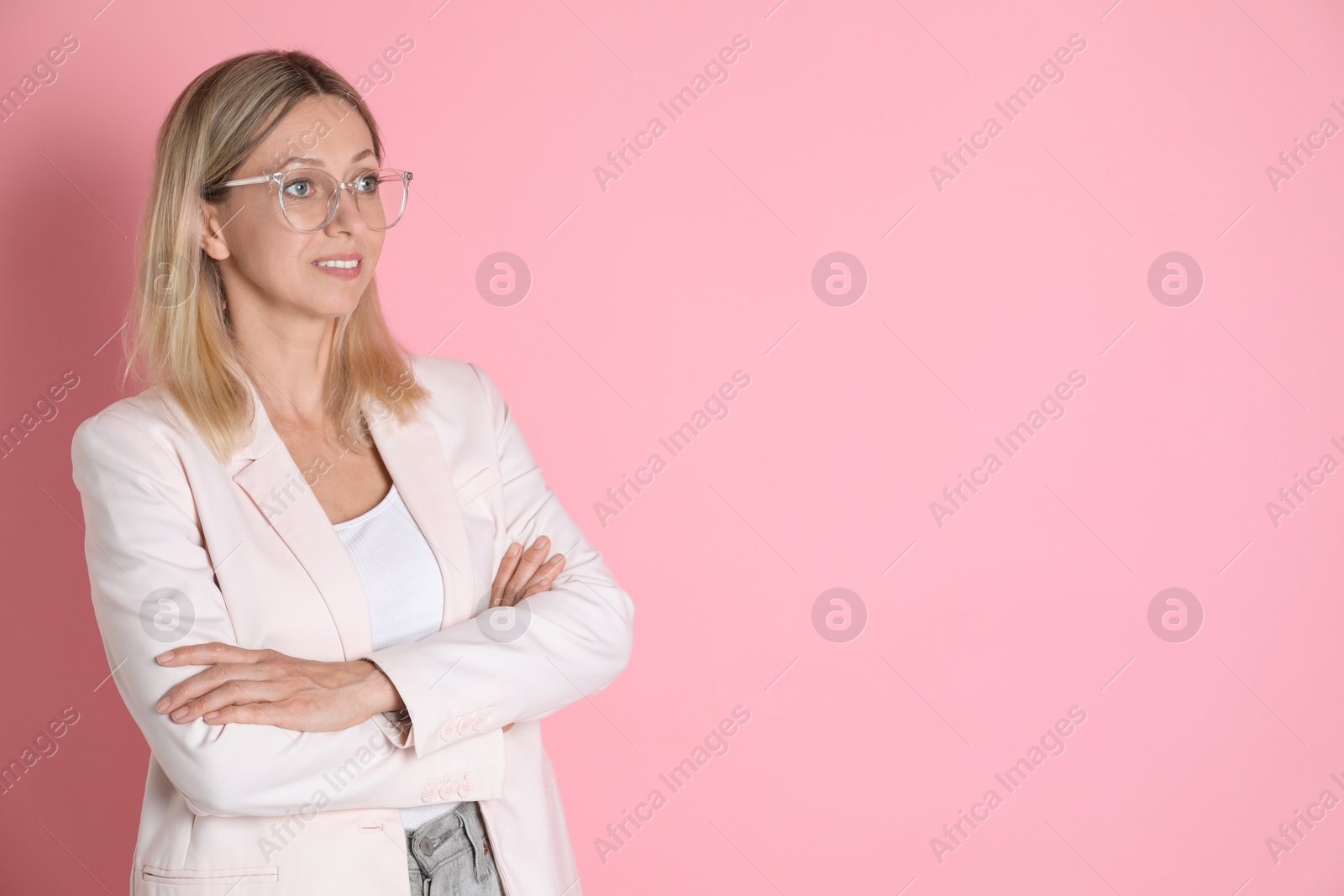 Photo of Beautiful smiling woman in glasses on pink background, space for text