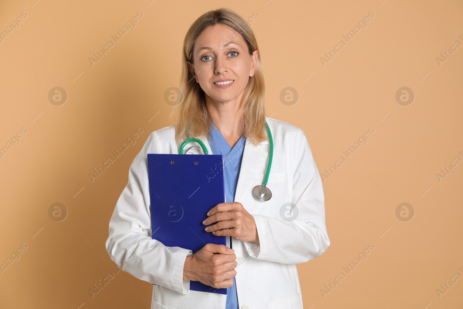 Photo of Portrait of doctor in medical uniform with stethoscope and clipboard on beige background