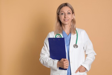 Portrait of doctor in medical uniform with stethoscope and clipboard on beige background