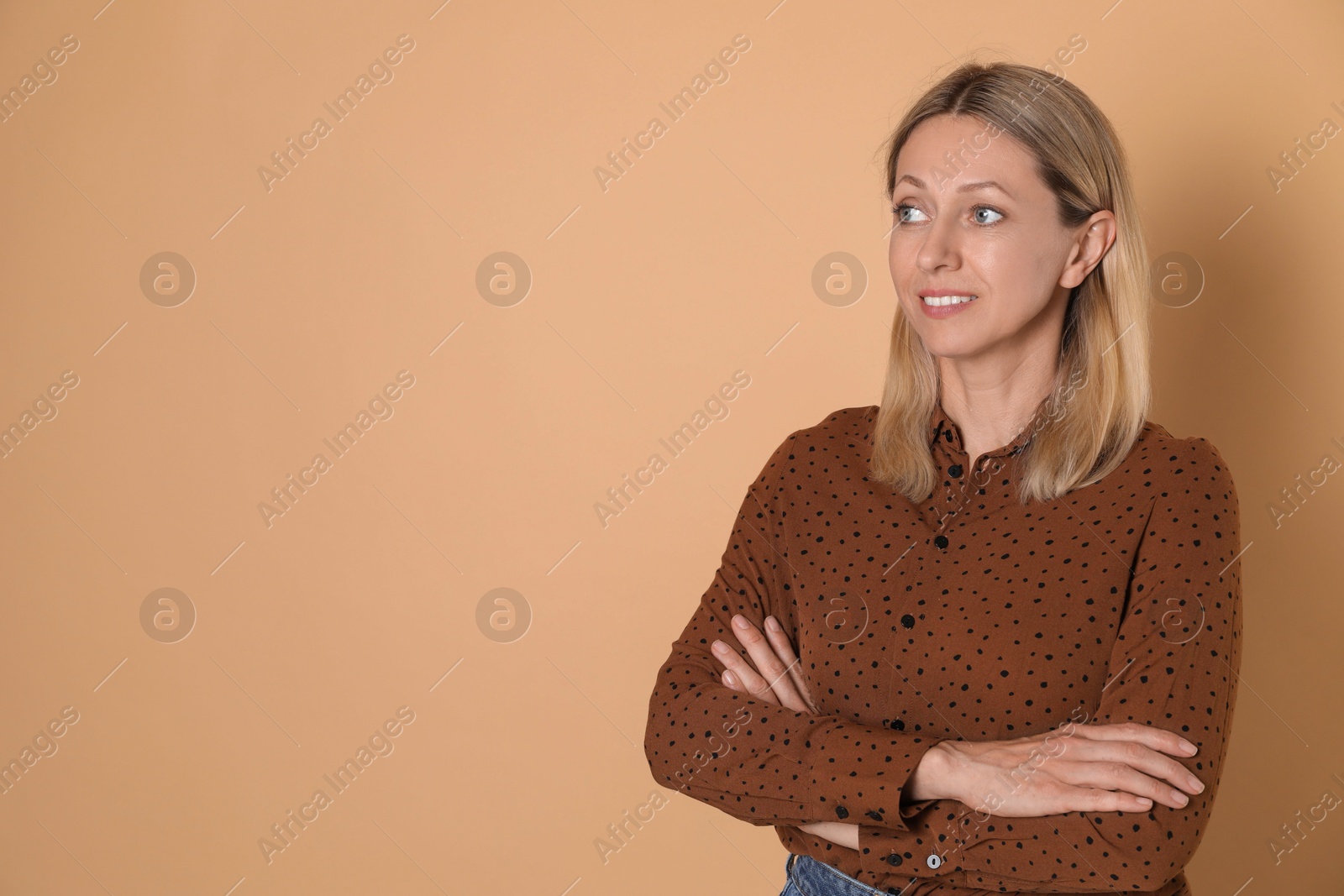 Photo of Portrait of beautiful smiling woman on beige background, space for text