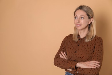 Photo of Portrait of beautiful smiling woman on beige background, space for text