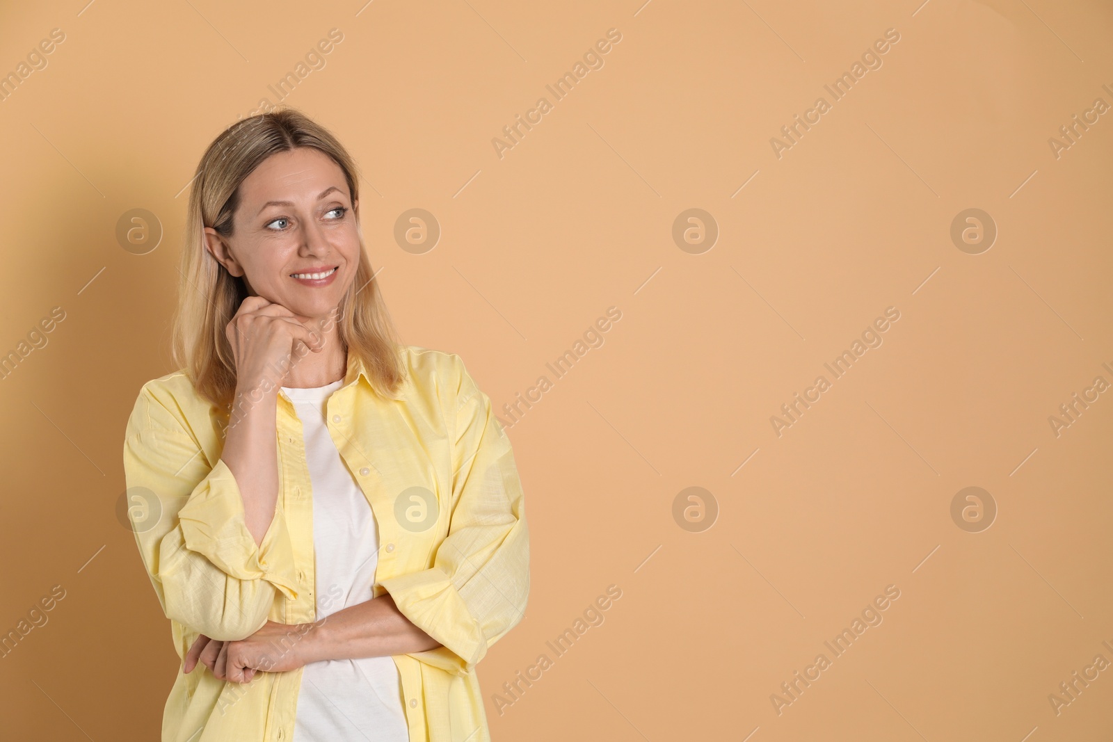 Photo of Beautiful smiling woman on beige background, space for text