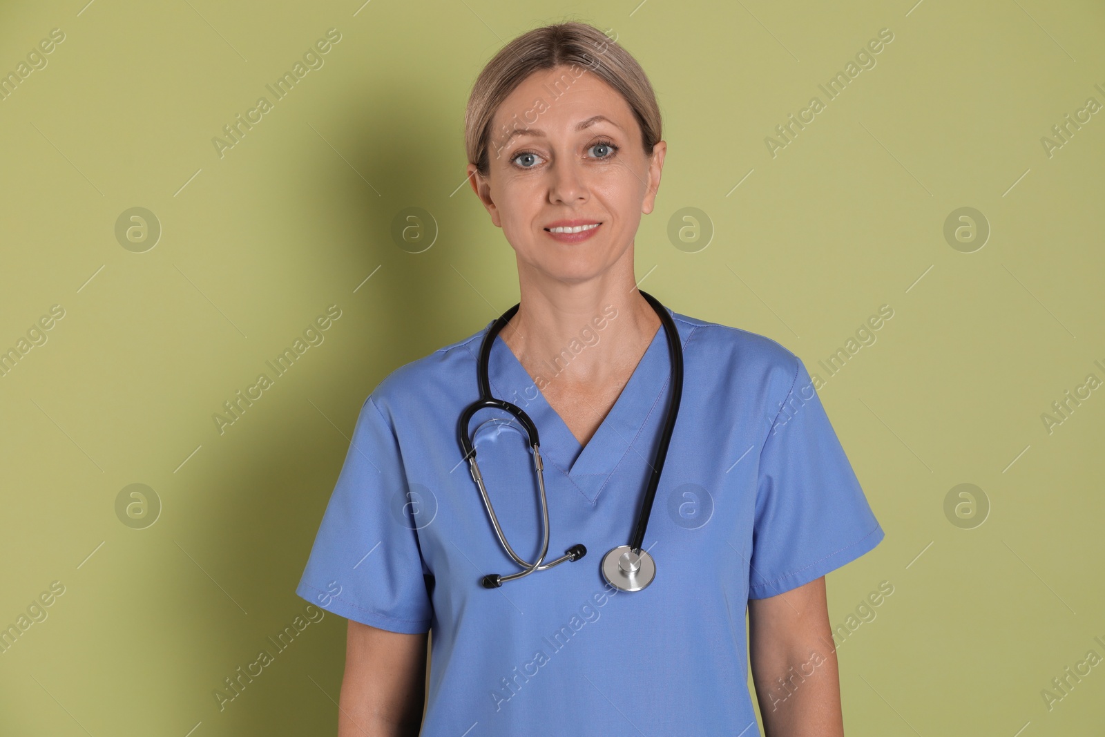 Photo of Portrait of nurse in medical uniform with stethoscope on light green background