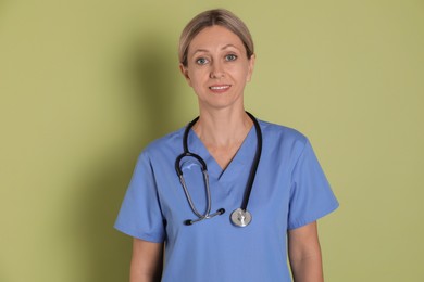 Photo of Portrait of nurse in medical uniform with stethoscope on light green background