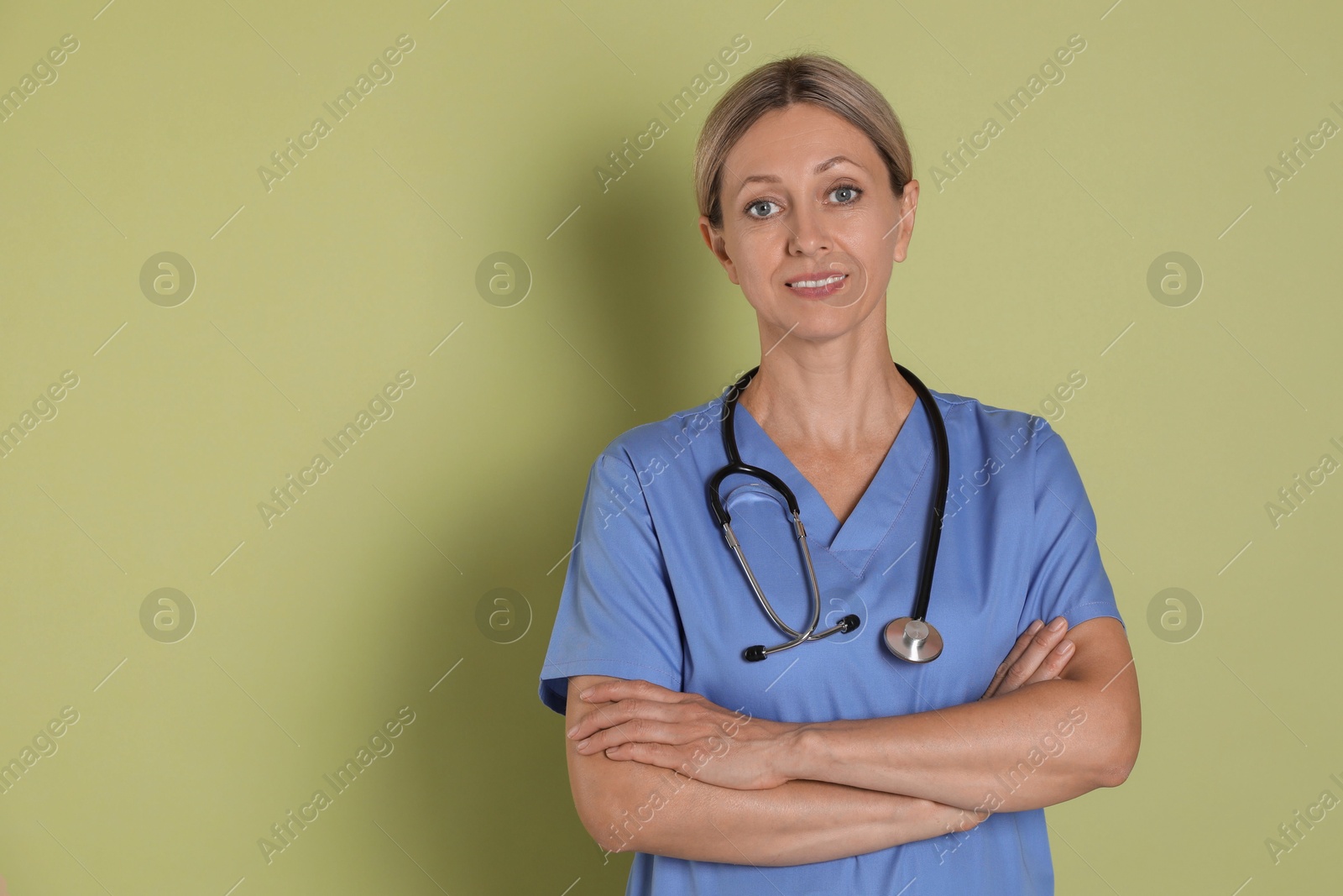 Photo of Portrait of nurse in medical uniform with stethoscope on light green background