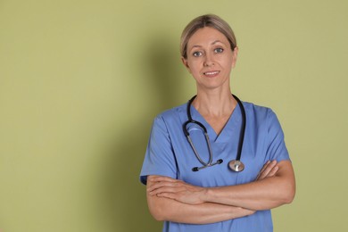 Portrait of nurse in medical uniform with stethoscope on light green background