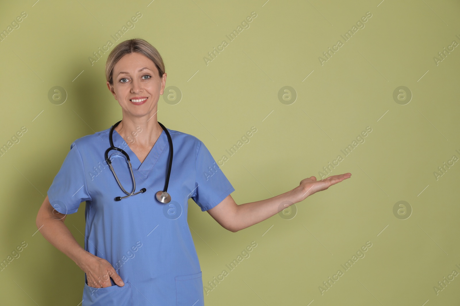 Photo of Portrait of nurse in medical uniform with stethoscope on light green background