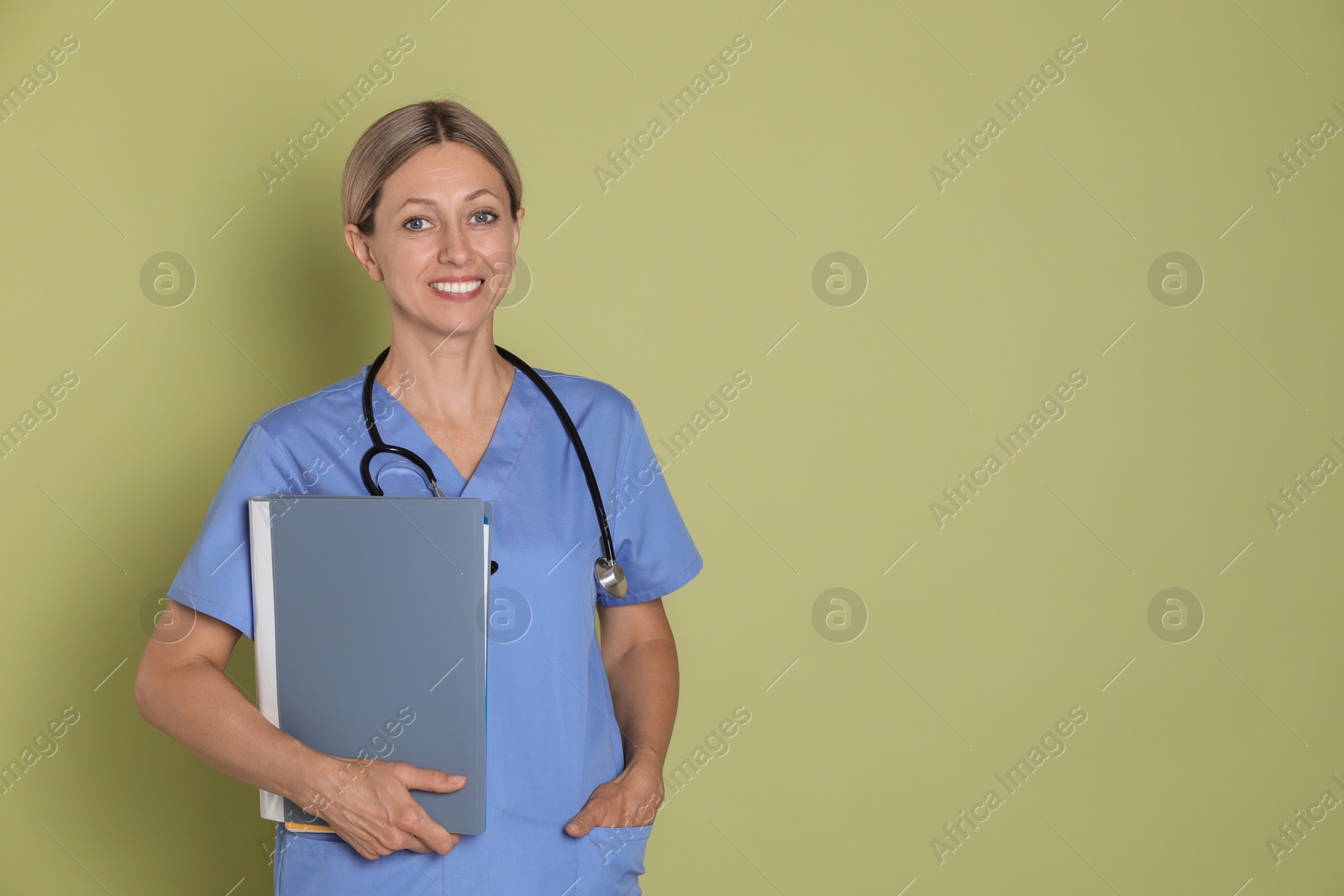 Photo of Nurse in medical uniform with folders on light green background, space for text