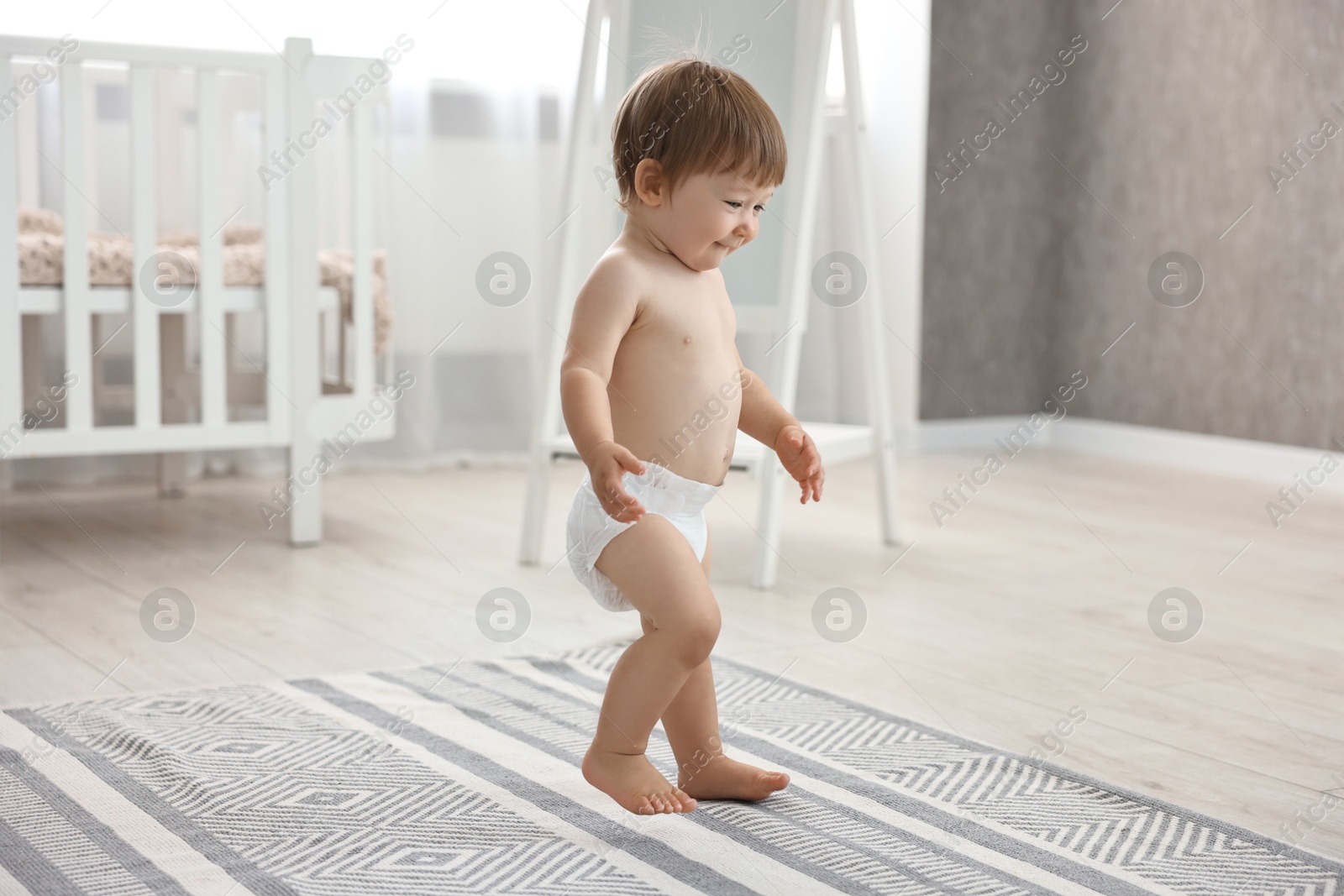 Photo of Cute little child in diaper at home