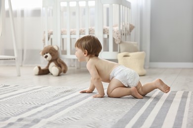 Cute little child in diaper at home