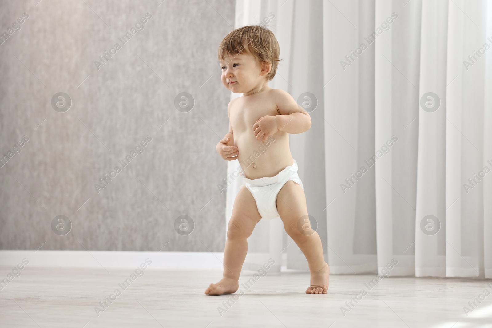 Photo of Cute little child in diaper at home