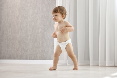 Photo of Cute little child in diaper at home