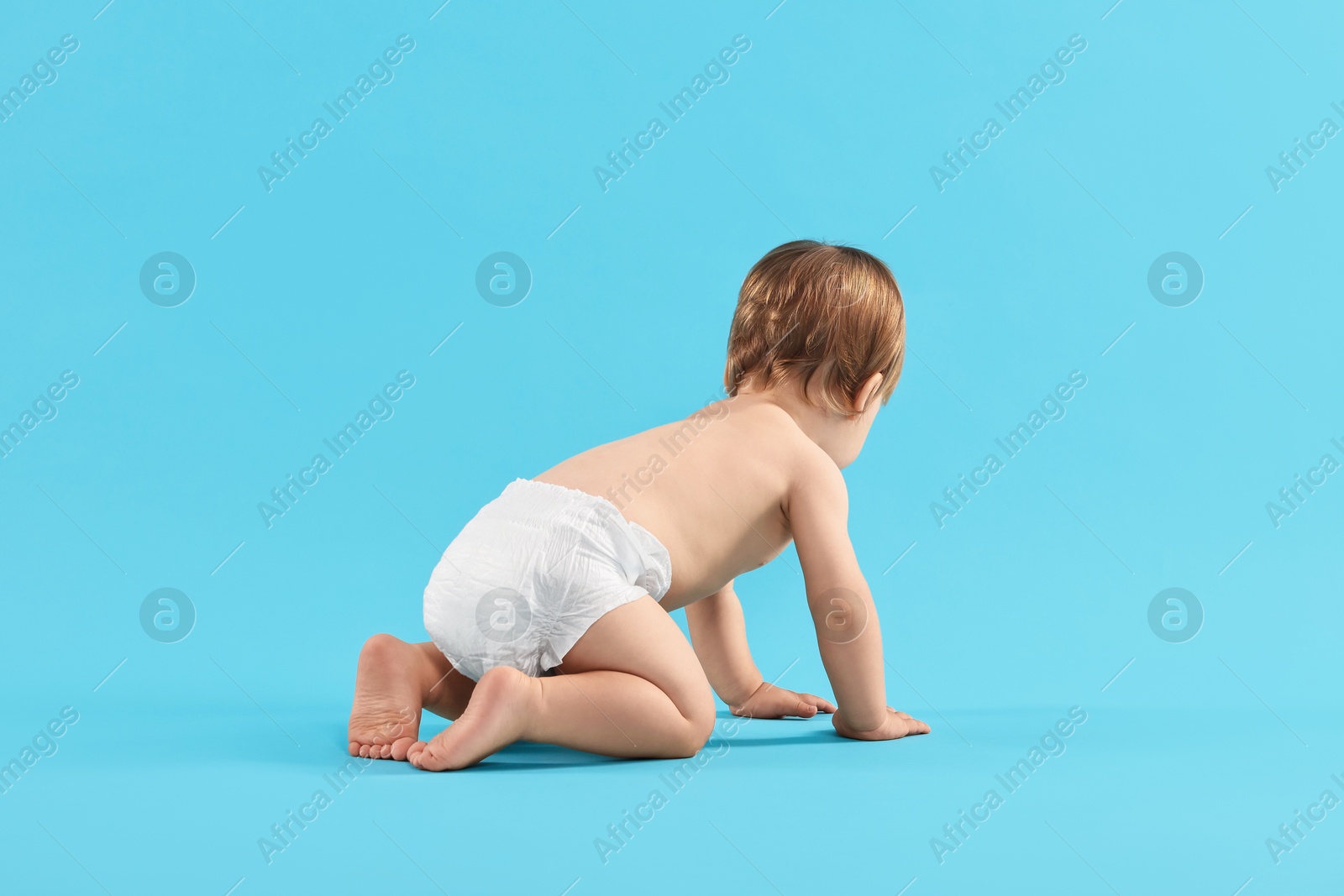 Photo of Little child in diaper on light blue background