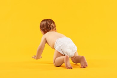 Photo of Little child in diaper on orange background