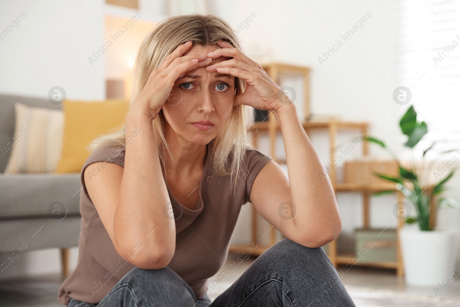 Photo of Menopause. Woman suffering from headache at home