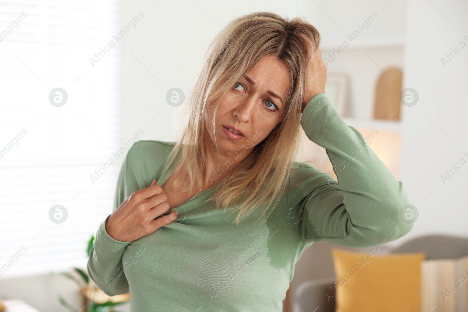 Photo of Menopause. Woman suffering from hot flash at home