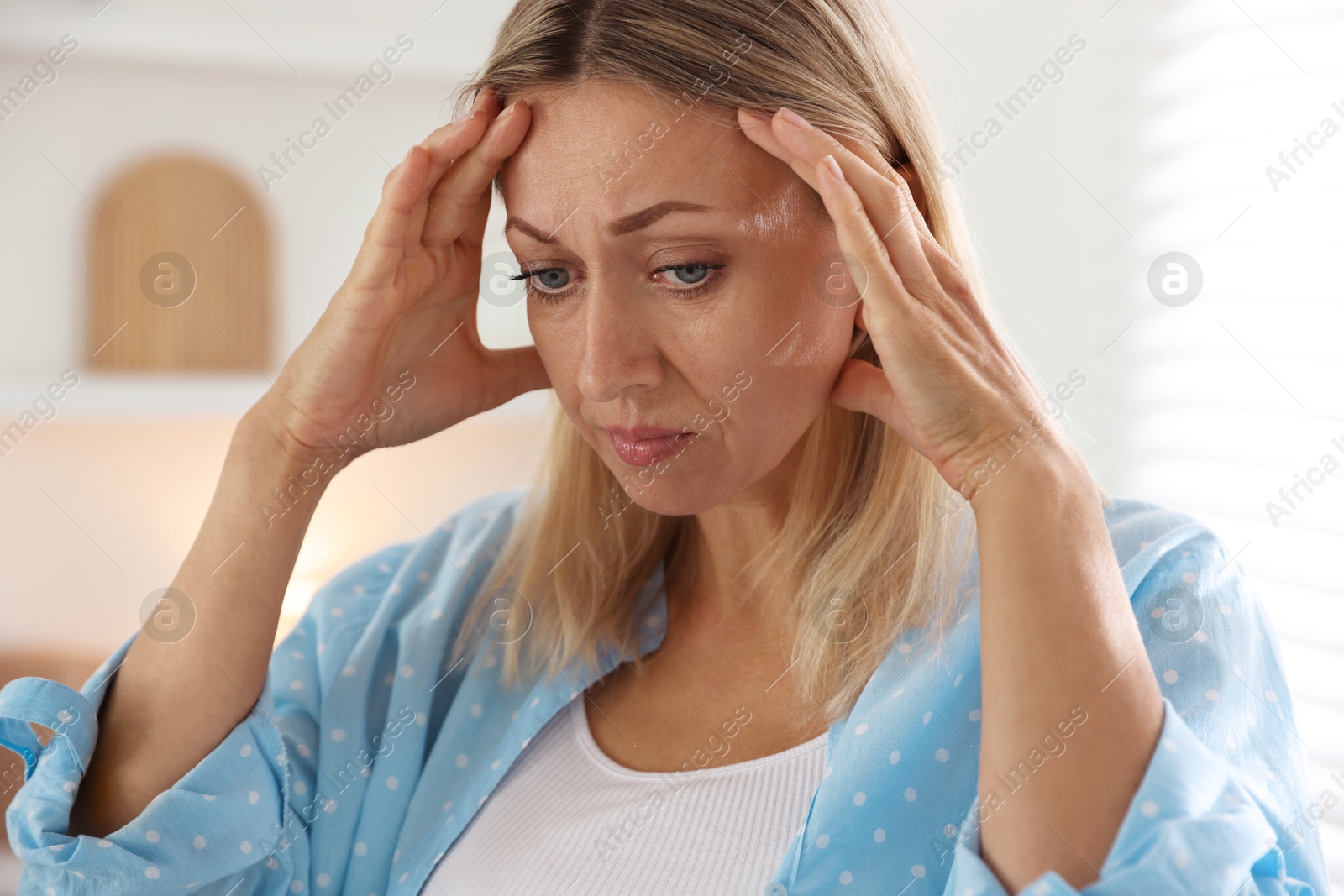 Photo of Menopause. Woman suffering from headache at home