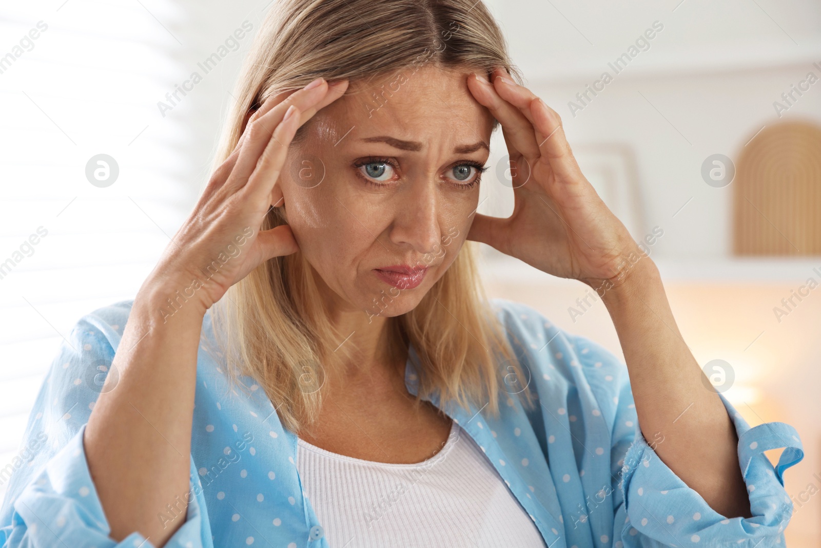 Photo of Menopause. Woman suffering from headache at home