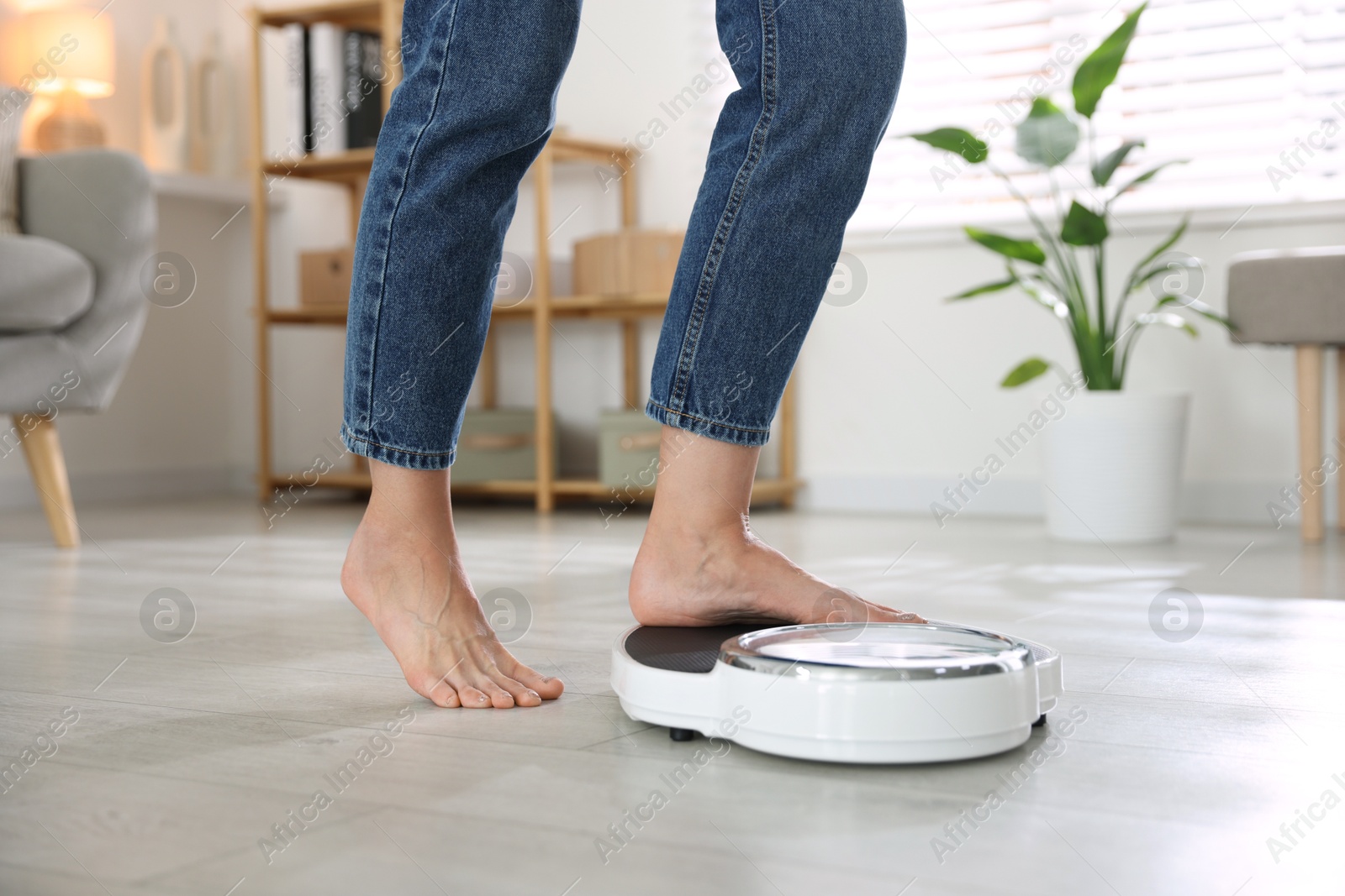 Photo of Menopause, weight gain. Woman standing on floor scales at home, closeup