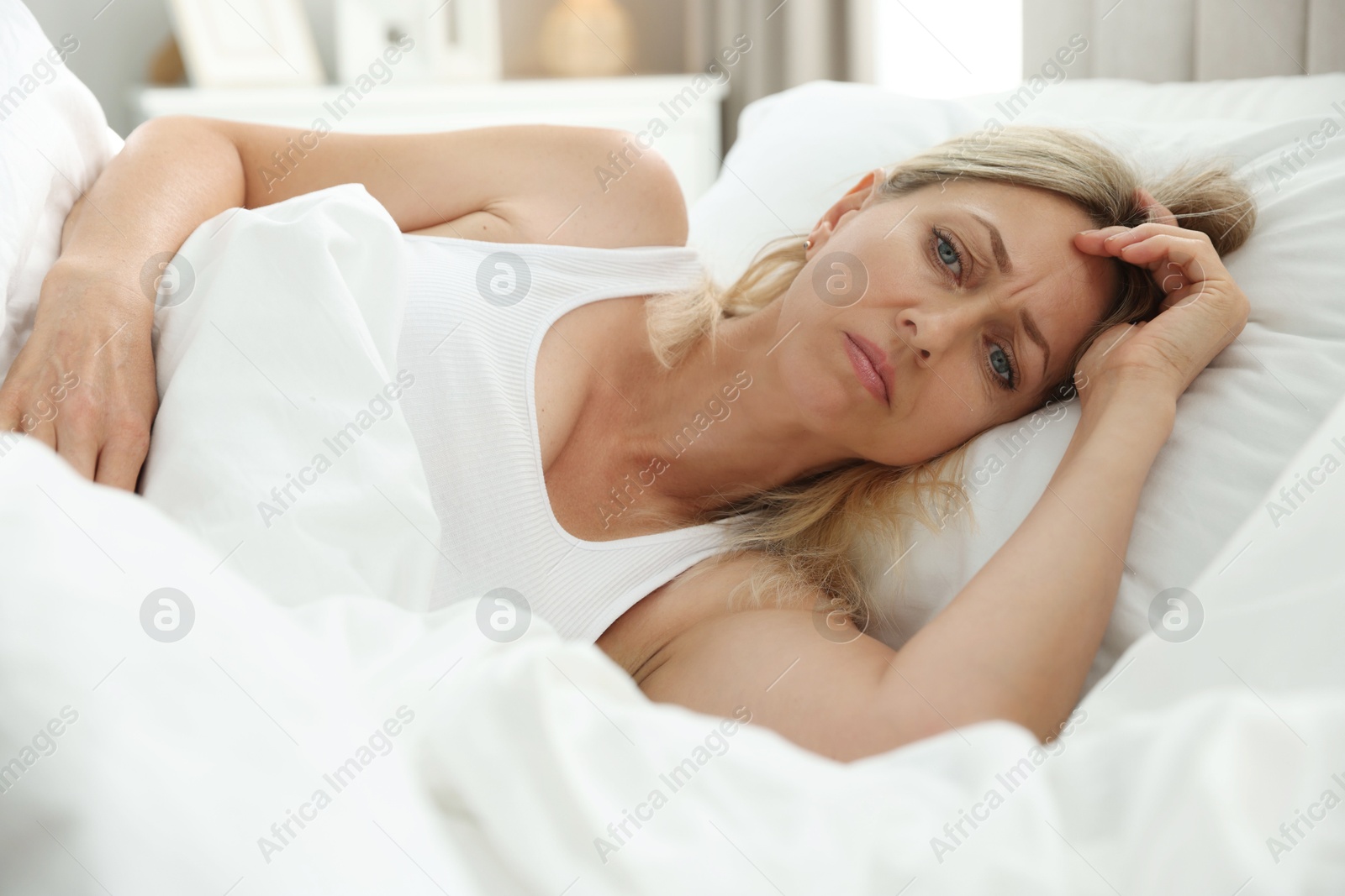 Photo of Menopause, sleep problems. Woman suffering from insomnia in bed indoors