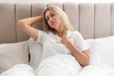 Menopause. Woman suffering from hot flash in bed at home