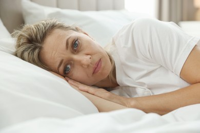 Menopause, sleep problems. Woman suffering from insomnia in bed indoors