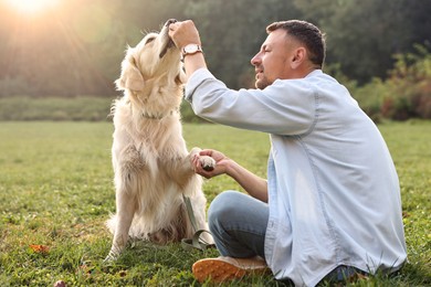 Man with cute Golden Retriever dog on spring day