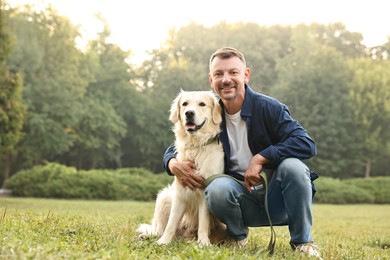 Photo of Smiling man with cute Golden Retriever dog on spring day