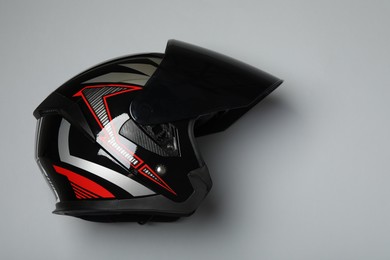 Modern motorcycle helmet with visor on gray background, top view. Space for text