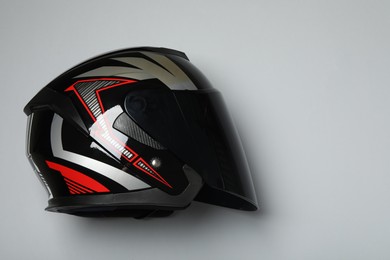 Modern motorcycle helmet with visor on gray background, top view. Space for text