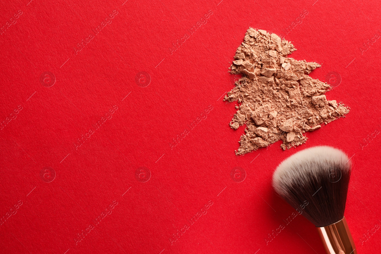 Photo of Christmas tree made of face powder and brush on red background, top view. Space for text