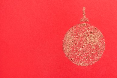 Photo of Christmas ball made with face powder on red background, top view. Space for text