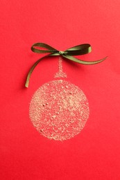 Photo of Christmas ball made with face powder on red background, top view