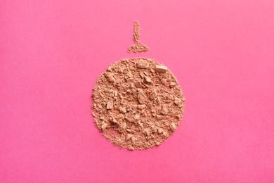 Photo of Christmas ball made with face powder on pink background, top view