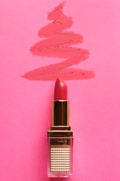 Photo of Christmas tree drawn with lipstick on pink background, top view