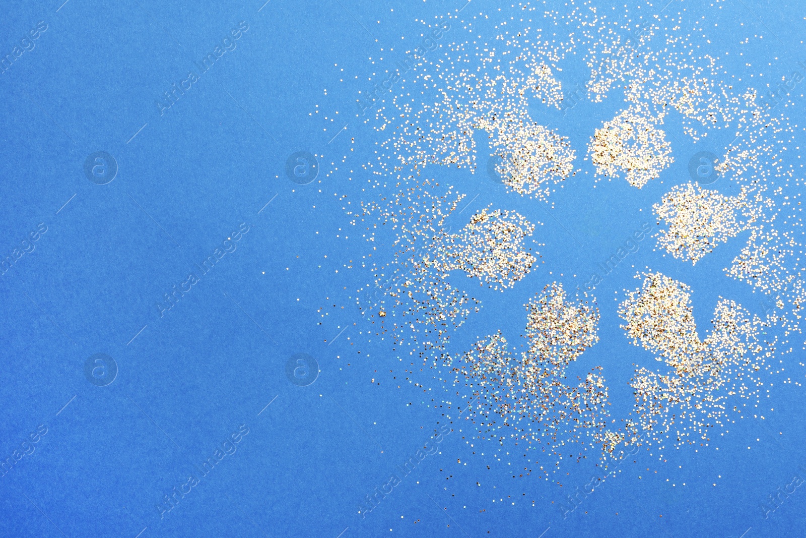 Photo of Snowflake made of golden glitter on blue background, top view. Space for text