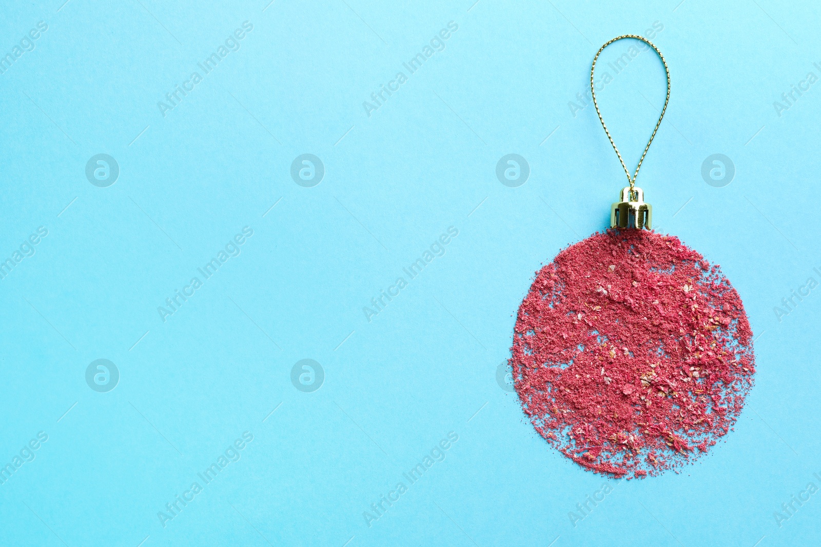 Photo of Christmas ball made with blush on light blue background, top view. Space for text