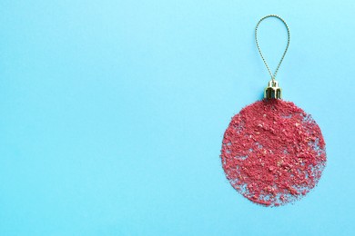 Photo of Christmas ball made with blush on light blue background, top view. Space for text