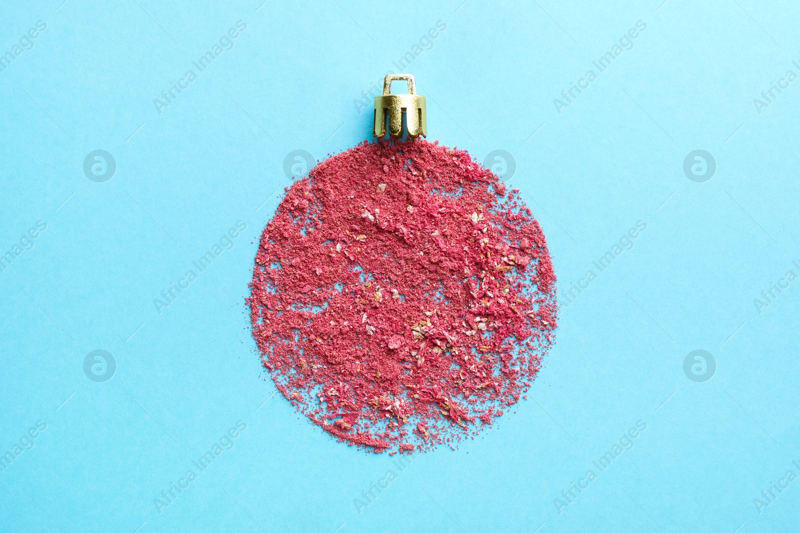 Photo of Christmas ball made with blush on light blue background, top view