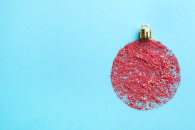 Photo of Christmas ball made with blush on light blue background, top view. Space for text