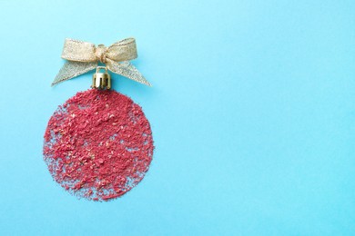 Photo of Christmas ball made with blush on light blue background, top view. Space for text