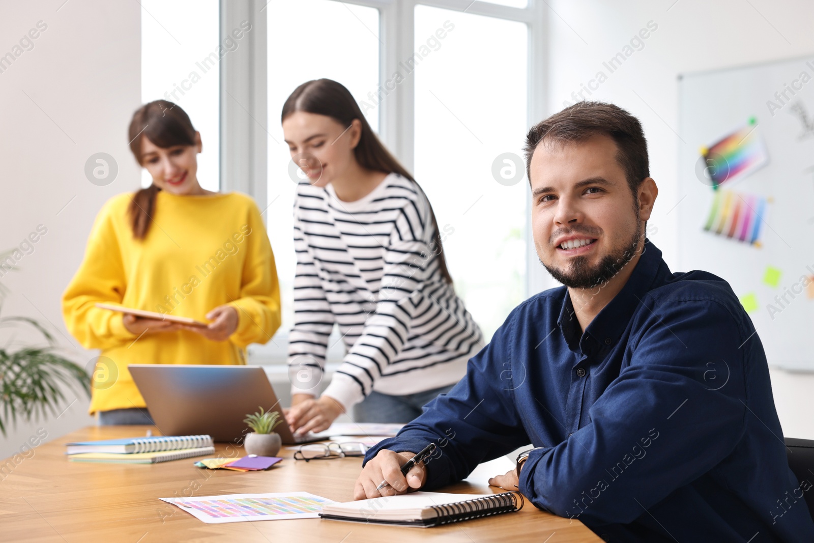 Photo of Portrait of happy young designer in office