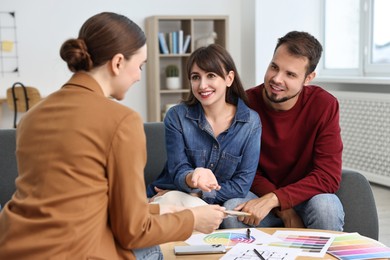 Designer discussing project with clients at table in office