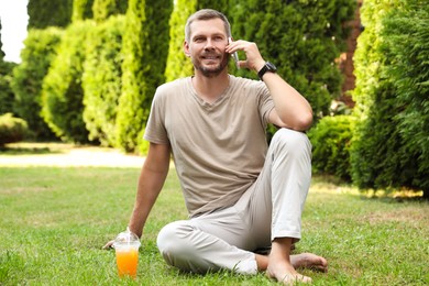 Photo of Man using smartphone on green lawn outdoors