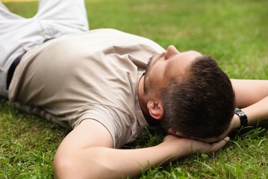 Photo of Man resting on green lawn in park